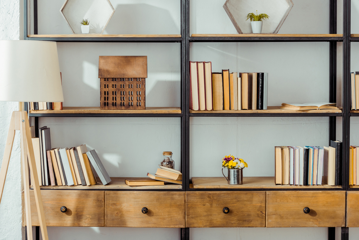 A wooden bookshelf decorated with personalized items and books.